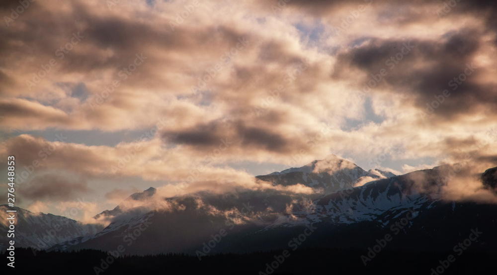 Sun rising on the Mountains surrounding the Seward Harbor in Alaska Sun rising on the Mountains surrounding the Seward Harbor in Alaska
