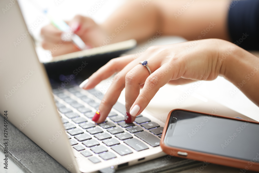 Woman sitting at desk and working at computer close up in hands. Woman sitting at desk and working at computer close up in hands.