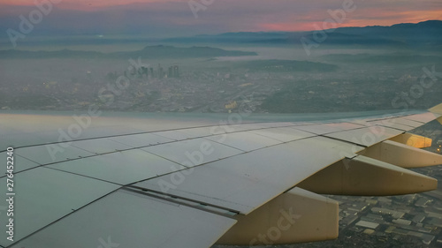 aerial view of sunrise and plane wing over los angeles
