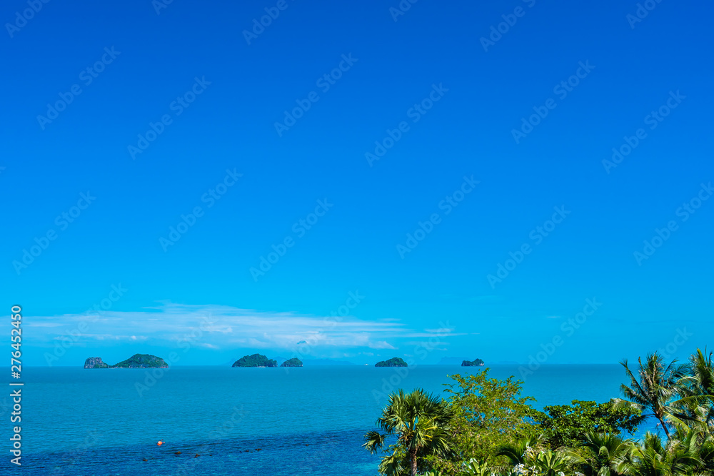 Fototapeta premium Beautiful tropical sea ocean with coconut palm tree on blue sky white cloud