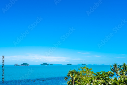 Beautiful tropical sea ocean with coconut palm tree on blue sky white cloud © siraphol
