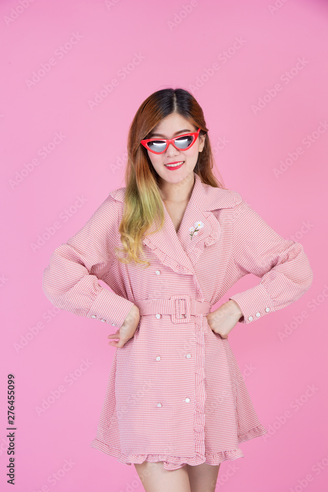 Fashion girl dress up with a hand gesture on a pink background.
