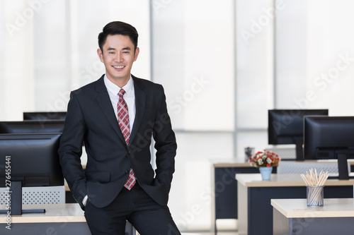 Businessman sitting on table in office..