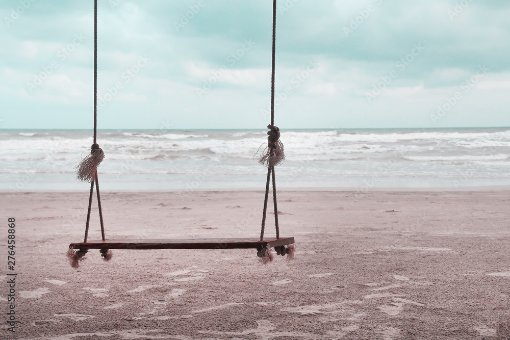 Single blank wooden swing with soft wind and landscape sand beach view , natural sea background