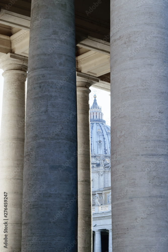 The St. Peters basilica visible through pillars in Vatican The St. Peters basilica visible through pillars in Vatican