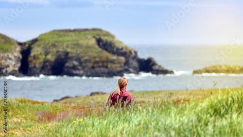 Girl walking in field near Atlantic Ocean in Newfoundland photo