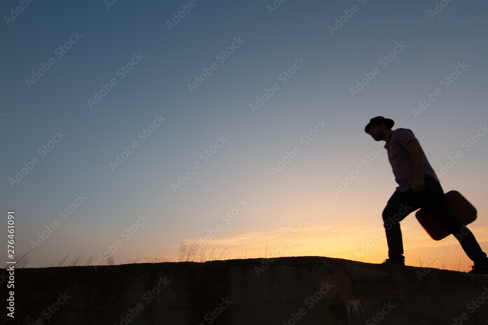 silhouette of man with suitcase at sunrise silhouette of man with suitcase at sunrise