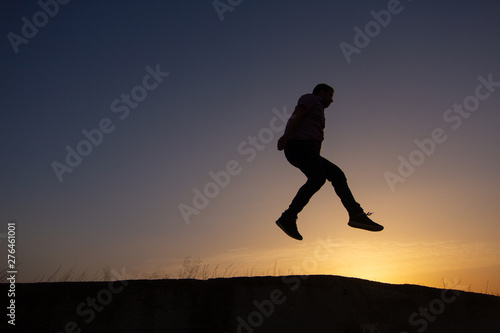 silhouette of man jumping at sunrise