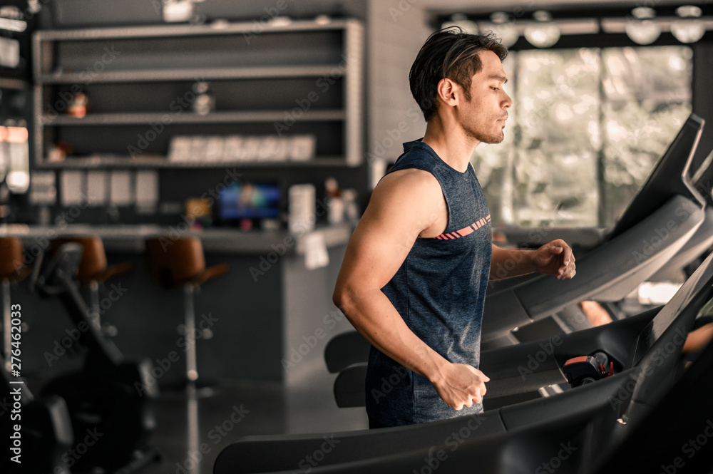 man in sportswear running on treadmill at gym man in sportswear running on treadmill at gym
