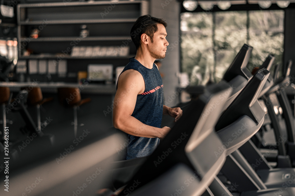 man in sportswear running on treadmill at gym man in sportswear running on treadmill at gym