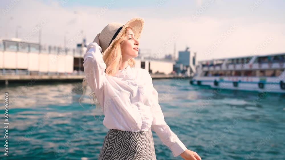 Slow Motion:Beautiful girl poses near bosphorus with view of Galata bridge and Istanbul.Traveler concept Slow Motion:Beautiful girl poses near bosphorus with view of Galata bridge and Istanbul.Traveler concept