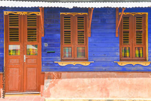 typical house of Martinique with flashy colors blue wall and brown door