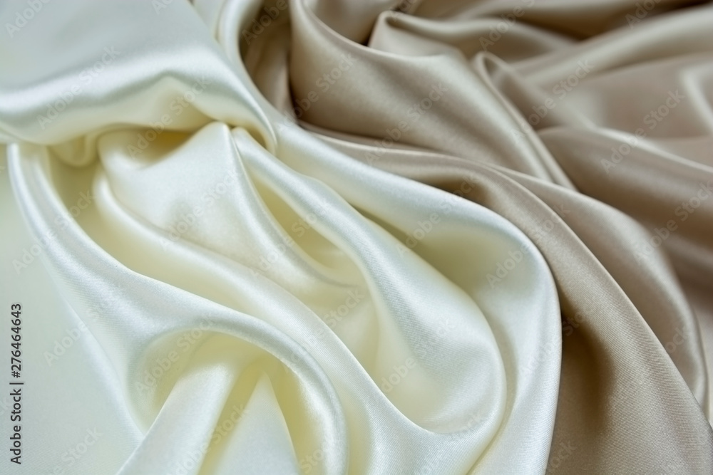 Obraz premium The texture of the satin fabric of white and beige color for the background