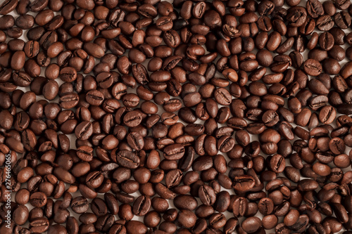 Texture background of coffee beans for design. Coffee grains scattered on the table