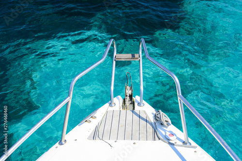 (Selective focus) Stunning view of a bow of a yacht sailing on a beautiful turquoise and transparent sea. Costa Smeralda (Emerald Coast) Sardinia, Italy. 