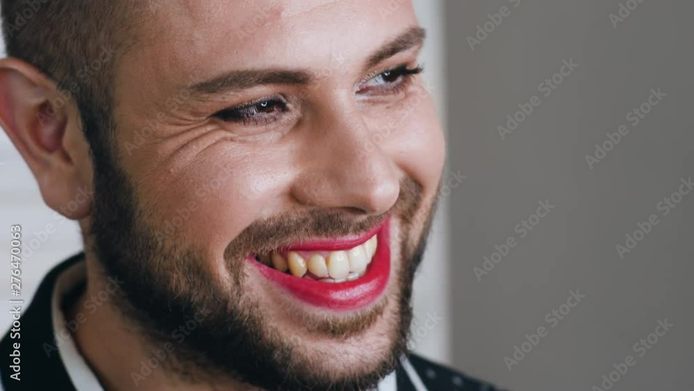 Young man with makeup winks and smiles Young man with makeup winks and smiles