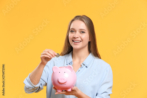 Young woman putting coin in...