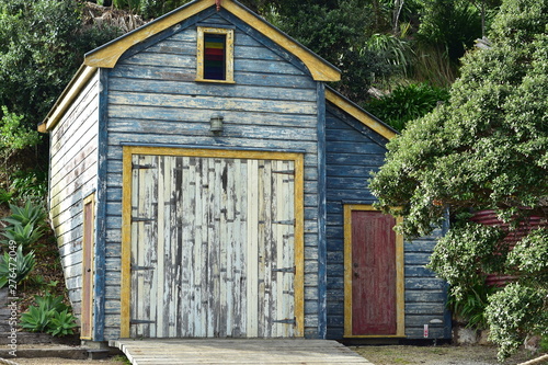 Historic wooden boat shed with paint peeling off weathered walls.
