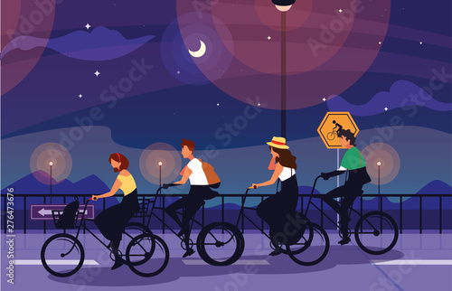 people riding bike in night landscape with signage for cyclist