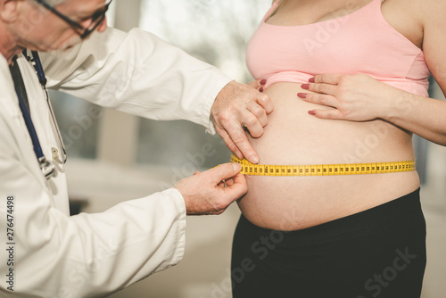 Doctor measuring belly size of pregnant woman
