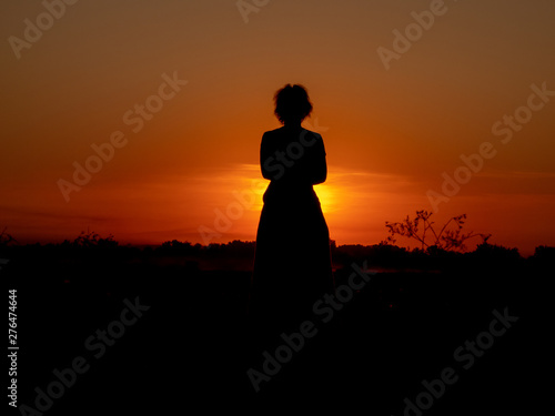girl watching the sunset in the field