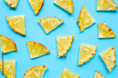 Fresh pineapple slices on blue background.