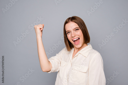 Porrait of charming cute nice pretty youth raise fists shout yeah hooray conquer prize isolated wear fashionable clothing isolated grey silver background photo