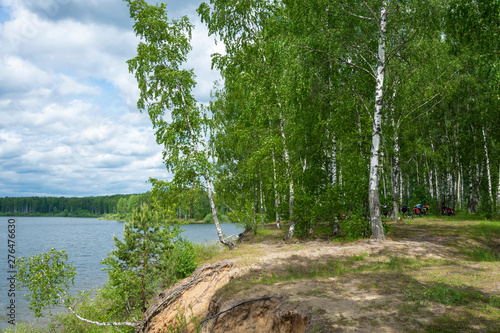 Parking for cyclists in a birch grove on a steep bank of the river.