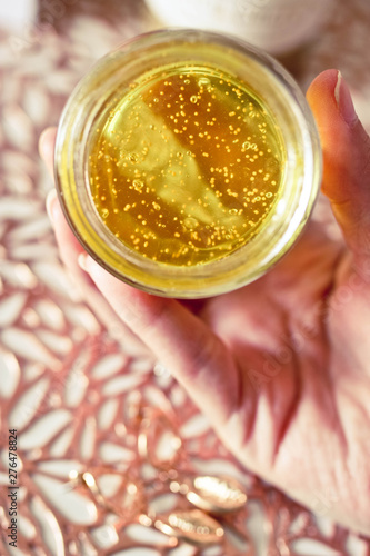 Woman's hand holding face mask. Close up view of cosmetic and spa product. Yellow face mask.