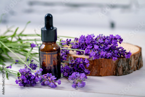lavender herbal oil and flowers on wooden background photo