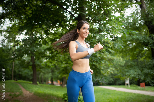 Sporty woman runner jogging during outdoor workout in park