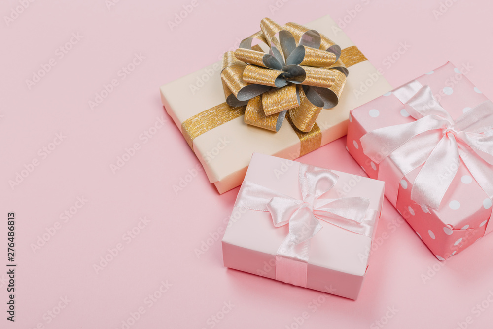 Gift box wrapped in pastel paper with pink ribbon on pink surface. Top view with copy space. Gift box wrapped in pastel paper with pink ribbon on pink surface. Top view with copy space.