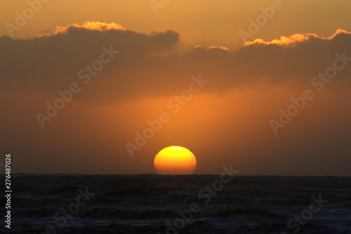 Fototapeta Naklejka Na Ścianę i Meble -  Orange sunset over horizon of sea 