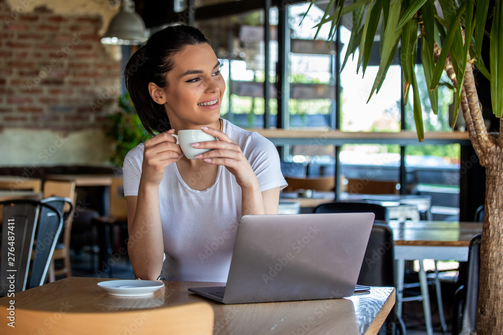 Young businesswoman is working in a cafeteria in her break.Woman taking a break. Enjoying work from coffee shop. Doing Business From coffee shop Young businesswoman is working in a cafeteria in her break.Woman taking a break. Enjoying work from coffee shop. Doing Business From coffee shop