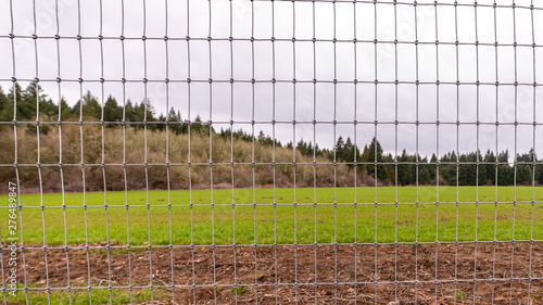 Metal fence protecting farm fields from animals and trespassers photo