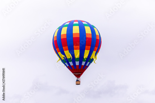 Woodburn, Oregon \ USA - 21 April 2019: A hot air balloon with blue, yellow and red stripes taking passengers into the sky