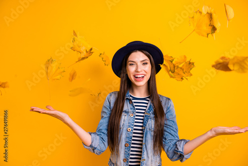 Portrait of her she nice-looking winsome attractive lovely optimistic cheerful cheery straight-haired lady throwing leaves isolated over bright vivid shine yellow background