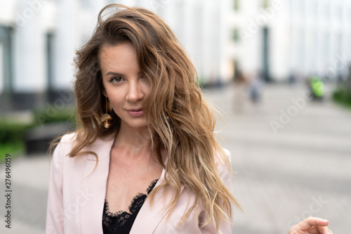 portrait close-up of a girl with long wavy hair, a beautiful natural face without makeup and a sweet smile. Lifestyle Street photography, a cool option for an advertising company © Денис Бухлаев