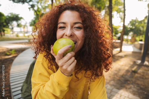 Happy young girl with red curly hair photo