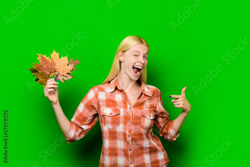 Winking blond woman with gold leaf. Autumnal mood. Autumn time. Autumn sale. Autumnal vogue trend. Autumn foliage. Autumn girl. Smiling woman playing with leaves. Happy girl having fun with leaf fall.