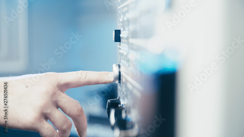 Person finger pushing a a button on industrial panel
