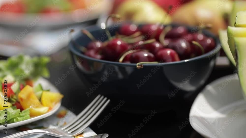 View from above of sweet watermelon, ripe cherries, delicious strawberries, apples, tasty peaches and sandwiches with lettuce and chicken lying on table. Concept of picnic, fruits and leisure. View from above of sweet watermelon, ripe cherries, delicious strawberries, apples, tasty peaches and sandwiches with lettuce and chicken lying on table. Concept of picnic, fruits and leisure.