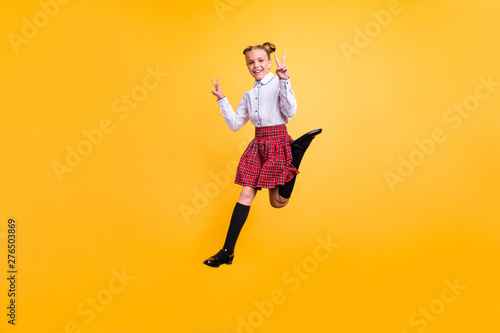 Full length body size view of her she nice attractive lovely cheerful cheery positive pre-teen girl having fun free time showing double v-sign enjoy isolated over bright vivid shine yellow background