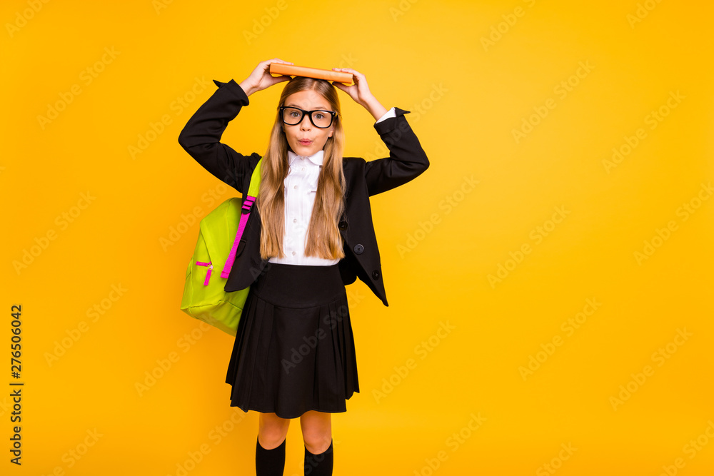 Portrait of cute kid hold book wear bag backpack rucksack standing isolated over yellow background Portrait of cute kid hold book wear bag backpack rucksack standing isolated over yellow background