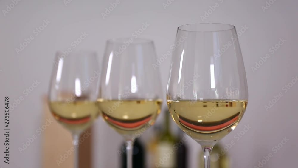 Glasses with white wine against blurred background, closeup Glasses with white wine against blurred background, closeup