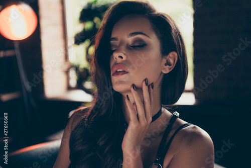 Close-up portrait of lovable winsome gorgeous attractive magnificent stunning charming wavy-haired lady in swordbelt enjoying life touching neck closed eyes at loft industrial interior wood photo