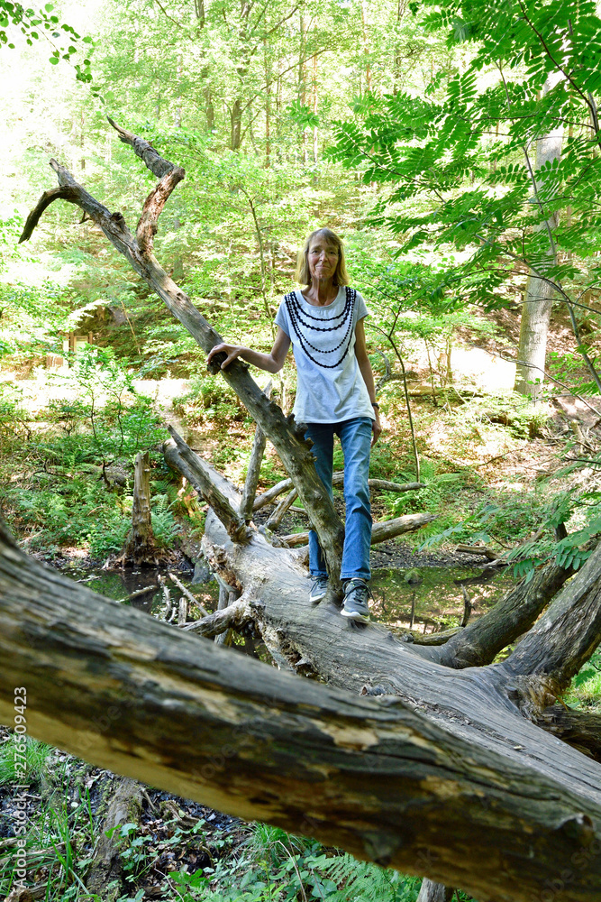 Obraz premium frau im wald an skurrilem baum
