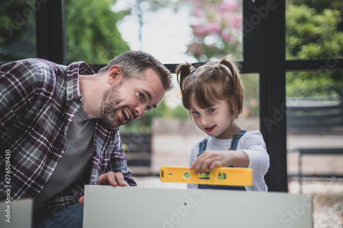 Father teaching Daughter how to use a spirit level