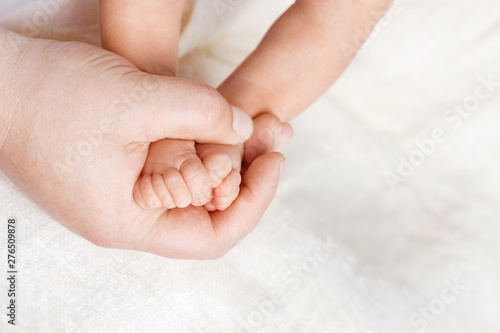  Newborn baby feet in father hands. Father holding legs of the kid in hands. Close up image.  Beautiful conceptual image of parenthood © fadzeyeva