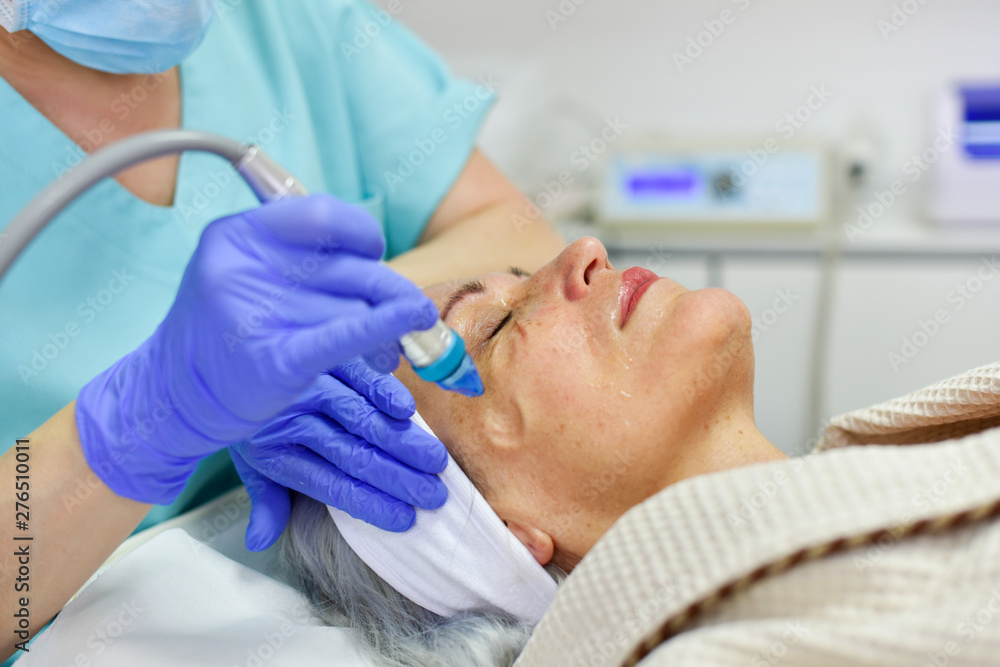Woman receiving oxygen facial treatment Woman receiving oxygen facial treatment